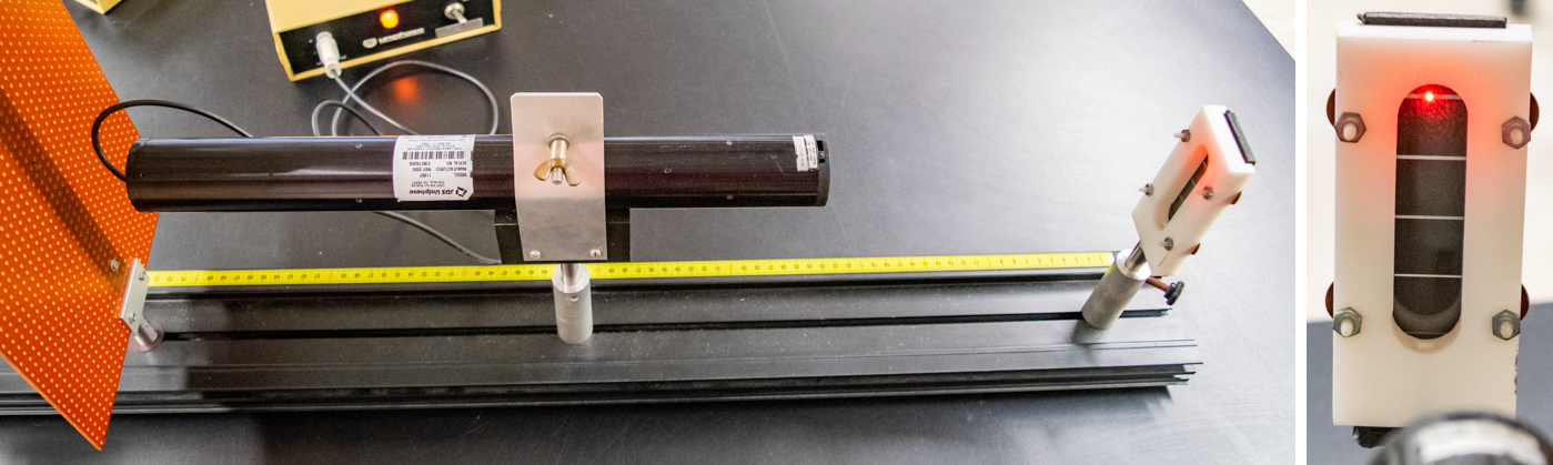 Laser mounted on black optics track pointed towards diffraction grating